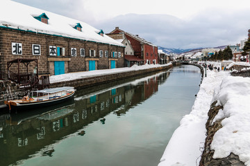 A beautiful landscape of  Otaru townscapes covered snow and tourist visiting and  rediscover the charms of Otaru's historical canal in winter season,Japan.