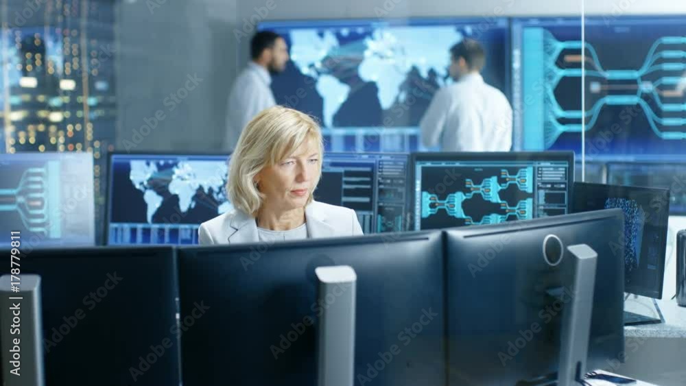 Fototapete System Monitoring Room Professional Female Operator Observes Correct Functioning of the Facility. In the Background People Working with Interactive Map. Shot on RED EPIC-W 8K Helium Cinema Camera.