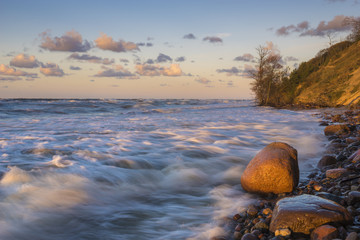 Wolin Island, Poland.Sunset over the sea during the storm, waves crashing against the stones