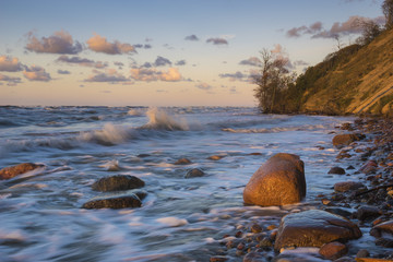 Wolin Island, Poland.Sunset over the sea during the storm, waves crashing against the stones