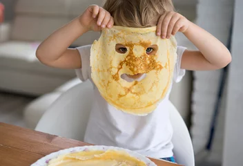 Foto op Plexiglas Little boy with a pancake instead of a mask on the face © natapetrovich