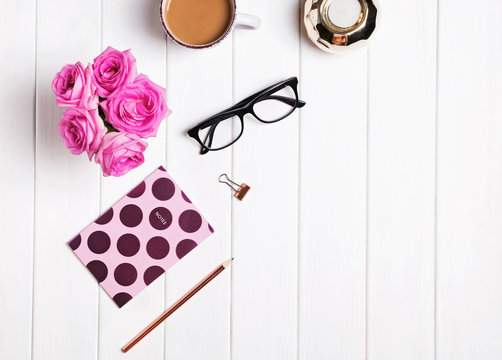 Stylish desk. Coffee, flowers, glasses and other accessories