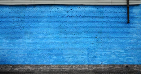 The texture of the brick wall of many rows of bricks painted in blue color