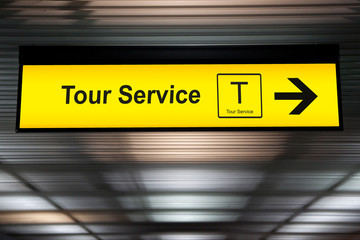 sign tour service at the airport with arrow for direction to tour counter service for tourist