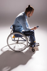 man in wheelchair using smartphone