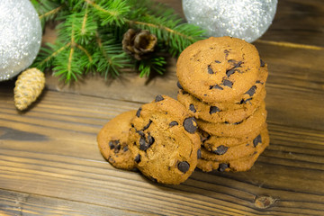 Obraz na płótnie Canvas Chocolate chip cookies in front of Christmas decoration on wooden table