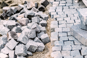 Granite cobblestone pavement details. Construction of pavement roads in progress