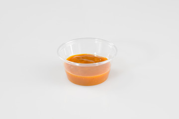 plastic cup sauce Relish mustard ketchup and mayonnaise condiments in clear containers on white background