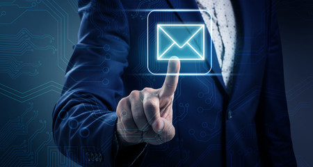 Businessman hand pushes on luminous email icon.