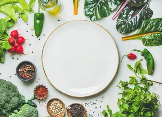  Fresh raw greens, unprocessed vegetables and grains over light grey marble kitchen countertop, wtite plate in center, top view, copy space. Healthy, clean eating, vegan, detox, dieting food concept © sonyakamoz