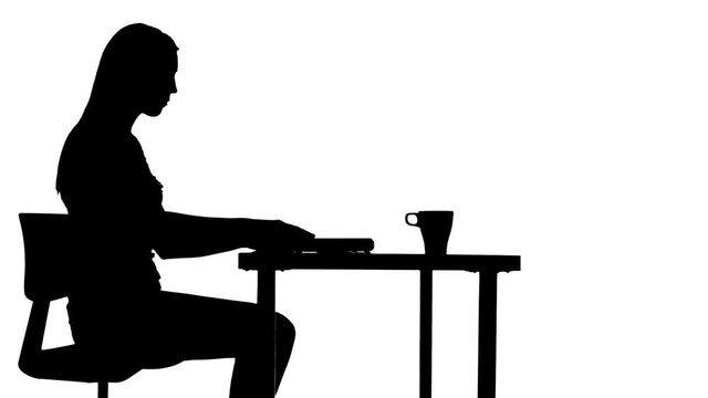 Female sits down at the table drinks coffee and uses a laptop silhouette
