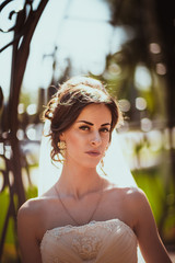 The beautiful brunette bride on a walk in park