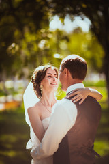 The bride and groom in the background of the park.