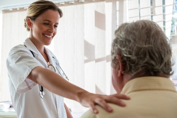 Fototapeta premium Doctor talking to senior man in retirement home