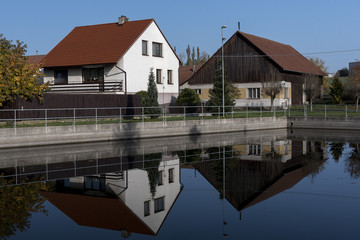reflection of village houses in the water of the fire brigade