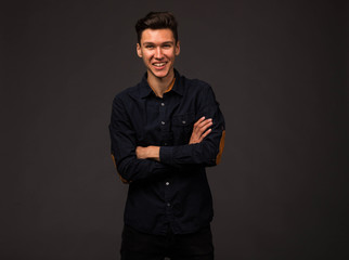Young happy man portrait of a confident businessman on a black background. Ideal for banners, registration forms, presentation, landings, presenting concept.