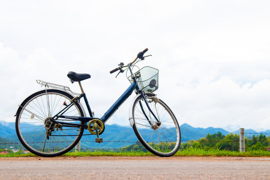 Fototapeta A bicycle stands at near of a runway and mountain with blue sky