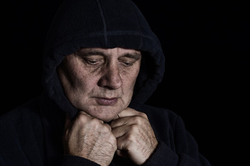 Nice low key portrait of mature man contemplating his hard life in darkness