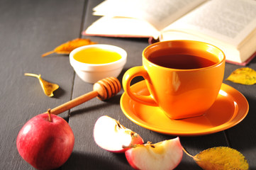 Autumn still life cup of tea, honey and book on the table
