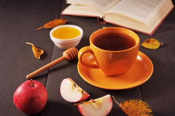 Autumn still life cup of tea, honey and book on the table
