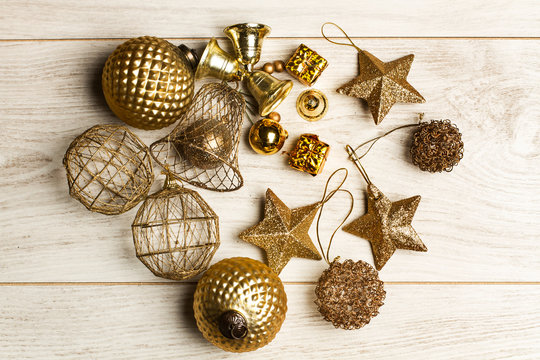 Bolas, estrellas, colgantes, adornos dorados sobre uun fondo de madera blanco r&uacute;stico. Vista superior y de cerca. Concepto: Navidad decoraci&oacute;n