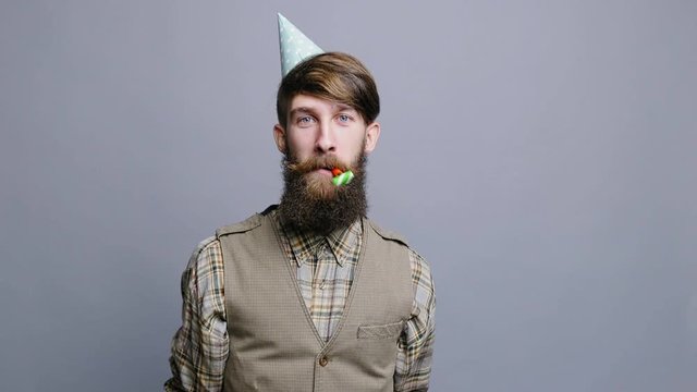 Bearded Man with party horn in party hat