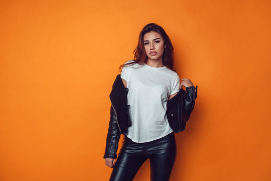 Sexy woman in white t-shirt and jacket on the orange background. Mock-up.