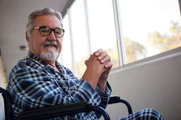 Portrait of senior man sitting on wheelchair in retirement home