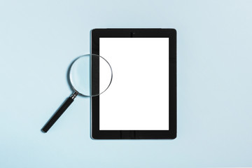 tablet pc with magnifier on the blue background.