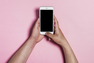 man hand hold a mobile phone and push, touch the screen on the pink background.