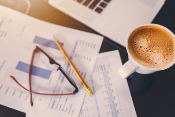 Top view of working desk with  cup of coffee and laptop