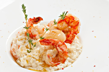  Delicious seafood risotto with fresh shrimp on a white plate.