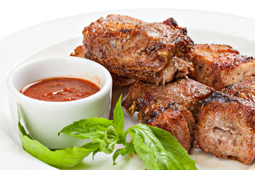 Roasted meat with sauce on a white background.