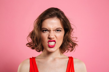 Close-up portrait of angry young woman with red lips looking at camera