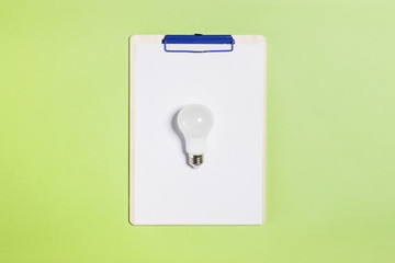 bulb with clipboard on the green background.