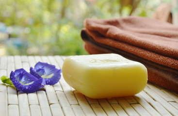 soap and towel with blue pea violet flower on bamboo mat