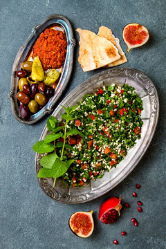 Middle Eastern traditional dinner. Authentic arab cuisine. Meze party food. Tabbouleh, muhammara, olives. Top view, flat lay, overhead