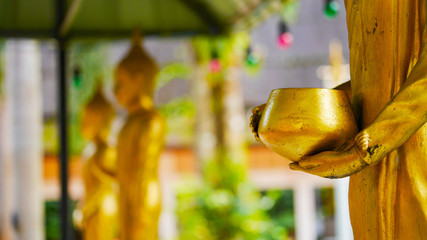 hand of golden buddha statue , hand on  almsbowl or monk's bowl