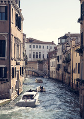 Fototapeta na wymiar Venetian transport boat, Narrow side canal with boats in Venice Italy, Classic canal in Venice, Picturesque alley with water and boats in Italian Venice