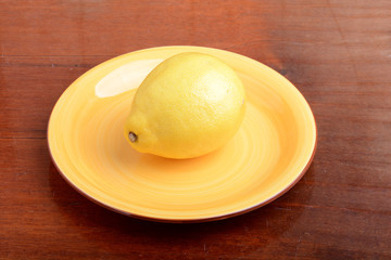 Fresh big natural lemon without leaves on a plate