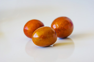 Close up of a pile of ripe zizyphus rich in vitamins and minerals on white backgraund. Shallow depth of focus.