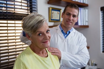 Obraz premium Physiotherapist examining neck of a female patient
