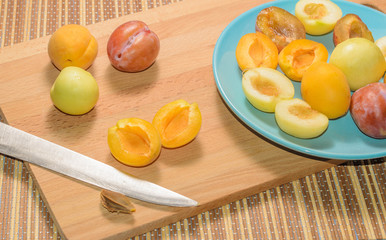 Summer fruits: apples, pears, apricots, plums on a blue plate