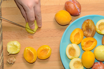 Hand cuts fruit on a wooden board