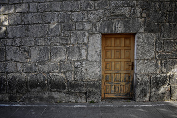 Fototapeta na wymiar Old wooden door at brick stone wall as background