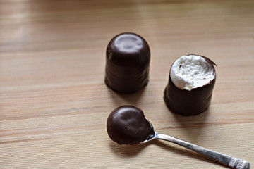 Chocolate mursh-mallow (munchmallow) whit silver spoon at wooden background