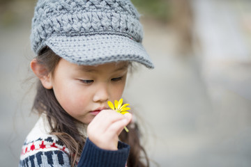 Little girl staring at the yellow flower