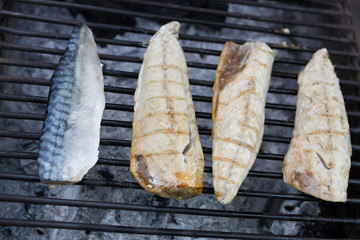 Cooking mackerels on charcoal grill
