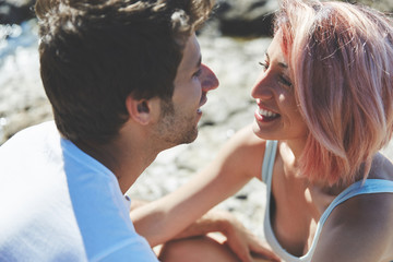 Happy woman looking at her boyfriend on beach