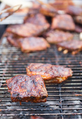 Pork ribs cooking on grill at bbq party